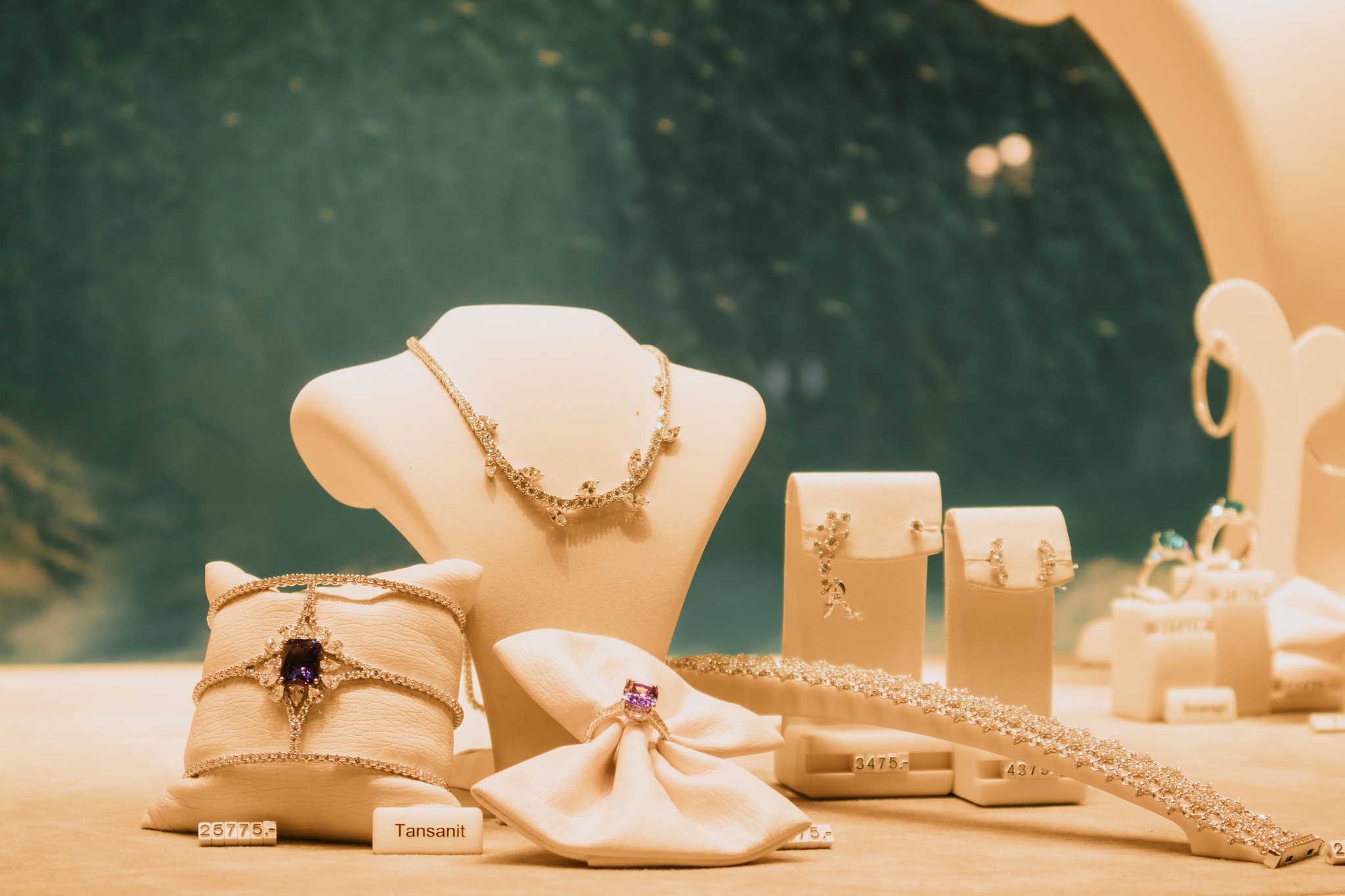 Bracelet, ring and earrings arranged on white display stands